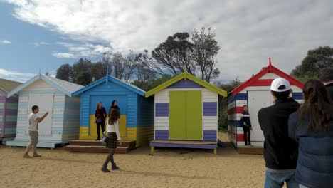 Touristen-Gehen-Und-Fotografieren-In-Brighton-Bathing-Boxes,-Melbourne,-Australien