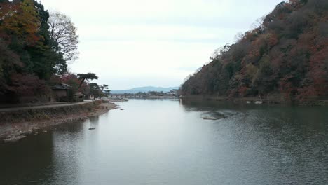 Arashiyama-slow-pullback-shot,-Katsura-river-and-Togetsukyo-bridge-in-background