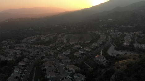 Aerial-Slide-Reveal-of-Sun-Setting-Behind-Mountain
