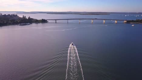 Aerial-speed-boat-chasing-and-following-by-the-drone-at-golden-hour-sunrise