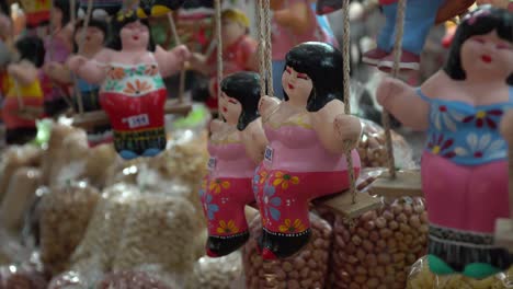 Fat-dolls-hanging-on-a-swing-in-Chiang-May-local-market,-Thailand-toys