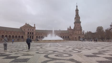 Moving-Forward-Toward-Fountain-in-Plaza-de-Espana,-Seville,-Rainy-Day,-SLOWMO