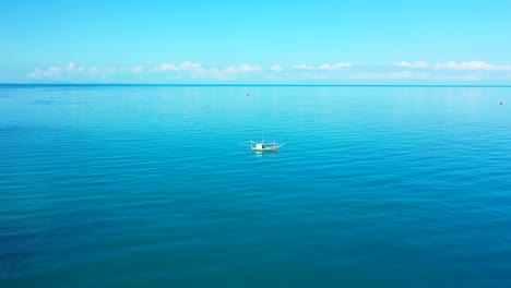 Barco-Pesquero-Anclado-En-Una-Tranquila-Laguna-Turquesa-Cerca-De-La-Costa-De-Una-Isla-Tropical-Al-Amanecer-Con-Un-Cielo-Azul-Brillante-En-Camboya