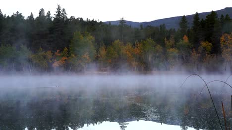 Early-morning-mist-over-lake-against-a-background-of-fall-foliage