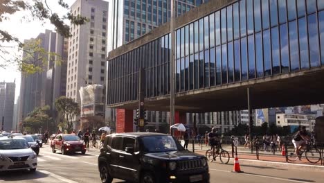 dozens-of-cyclists-and-cars-crossing-the-Paulista-avenue,-in-front-of-the-Museum-of-Art-of-Sao-Paulo,-MASP