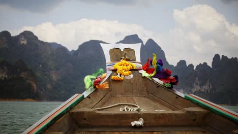 colorful-ribbons-waving-in-wind-on-longtail-boat-in-khao-sok,-slow-motion