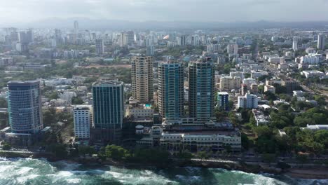 Incredible-esenico-flight-from-the-malecon-of-Santo-Domingo-where-we-see-the-big-city-and-the-Caribbean-sea,-lots-of-waves-and-pleasant-weather