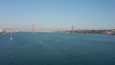 Aerial-shot-of-a-boat-turning-on-the-river-Tejo