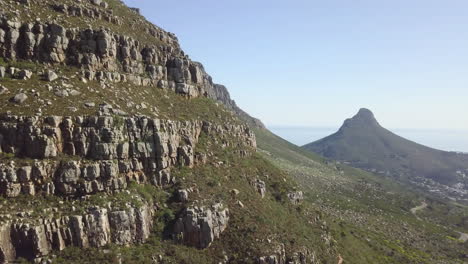 4K-high-quality-aerial-sunny-blue-sky-footage-of-spectacular-scenic-Lion's-Head-Mountain,-rocky-hills-with-hiking-trails,-Atlantic-Ocean-coast-panorama-in-Western-Cape,-Cape-Town,-South-Africa