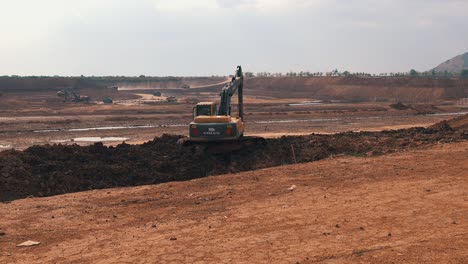 Wide-Shot-of-a-Digger-Excavating-Soil-on-a-Large-Construction-Site-in-Asia