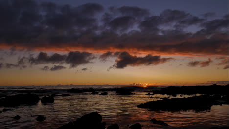 TimeLapse---Beautiful-golden-sunset-with-clouds-aglow-over-ocean-and-moving-across-quickly