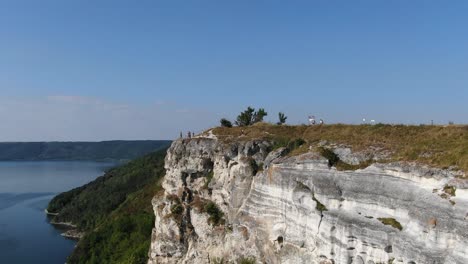 Aerial-VIew-of-People-Looking-Over-a-Cliff-on-a-River-on-a-Bright-Sunny-Day