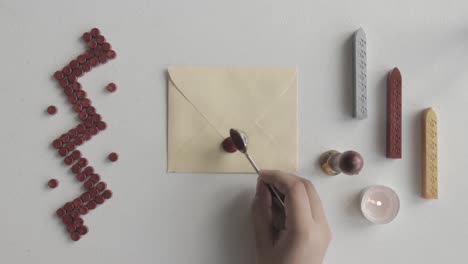 Close-up-on-Hand-Putting-Melted-Red-Wax-on-Letter-Envelope