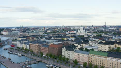 Slow-aerial-pan-of-buildings-and-cathedral-along-Helsinki-waterfront-at-dusk,-Finland