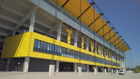 Große-Buchstaben-Des-Tivoli-Fußballstadions-In-Der-Deutschen-Stadt-Aachen-Mit-Einer-Fußgängerbrücke-über-Einer-Großen-Straße