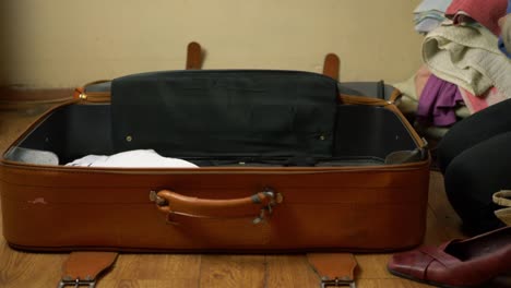 Woman-packing-old-brown-suitcase-time-lapse