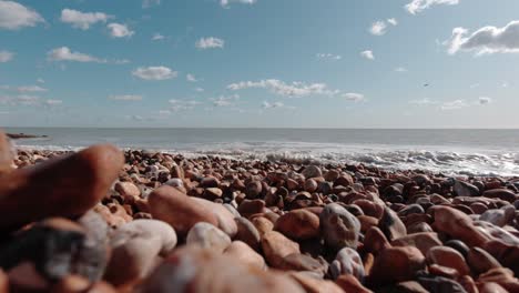 Close-up-of-pebble-stone-beach-in-Pevensey,south-England-on-a-sunny-day-while-waves-crashing-gently-to-the-shore
