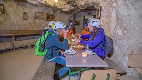 Eine-Gruppe-Junger-Touristen-Genießt-Lokalen-Aufschnitt-In-Einer-Höhle