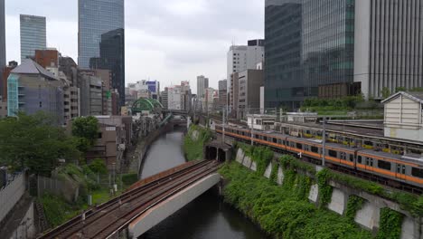 Tren-De-La-Línea-Chuo-Corriendo-En-Cámara-Lenta-Al-Lado-De-La-Estación-De-Ochanomizu-En-Tokio,-Japón---Amplia-Toma-En-Cámara-Lenta