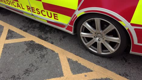 UK-NHS-emergency-rapid-response-medical-rescue-service-car-outside-hospital-pan-left-down