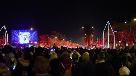 Laser-show-during-Paris-city-celebrates-New-Year's-with-huge-crowd-people-on-street-Champs-Élysées-before-the-start-of-video-mapping-fireworks-arrival-of-the-new-year