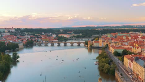 Aerial-Drone-flying-Over-Charles-Bridge,-Legion-Bridge,-Prague-Over-River-Vltava-During-Sunset-In-Czechia