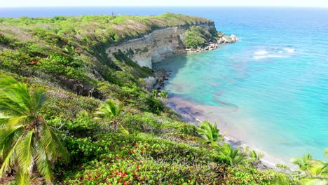 Scenic-flight-crossing-the-cliff-in-Breton-beach-Maria-Trinidad-Sánchez,-with-a-view-of-the-old-French-cape-and-the-blue-waters,-and-the-beautiful-vegetation-of-the-area