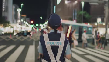 Mujer-Policía-Dirigiendo-A-La-Multitud-En-La-Calle-Durante-El-Festival-Yoiyama-En-El-Festival-Gion-Matsuri-Por-La-Noche-En-Kyoto,-Japón