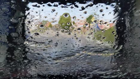 Clean-water-and-wax-sheen-off-of-a-car-windshield-as-it-travels-through-a-tunnel-carwash