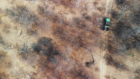 Aerial-View-Of-A-Four-Wheeled-Vehicle-Driving-On-The-Sandy-Trail-In-Kalahari-Desert,-Africa---Aerial-Drone-Shot