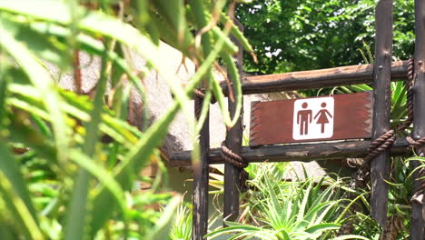 Focus-pull-of-a-bathroom-sign-in-a-nature-reserve-in-slow-motion