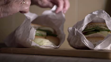 Elderly-lady-with-freshly-prepared-sandwiches-in-bags-medium-shot