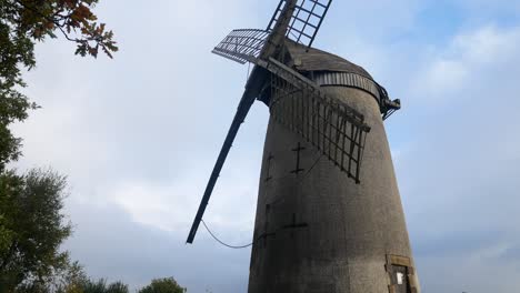 Bidston-hill-vintage-countryside-windmill-flour-mill-English-landmark,-female-jogger-running-through-scene