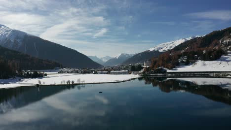beautiful-flight-over-Davos-lake-Switzerland-with-a-boat-in-the-reflecting-waters