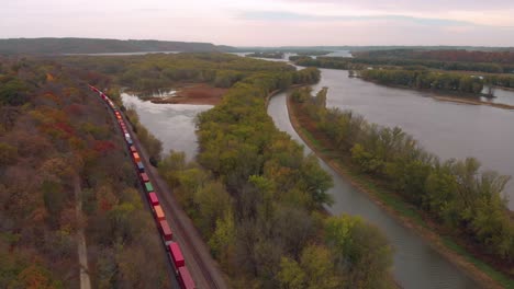 Freight-Train-Aerial-View-with-hundreds-of-Cars-transports-through-the-Autumn-Woods-of-Illinois