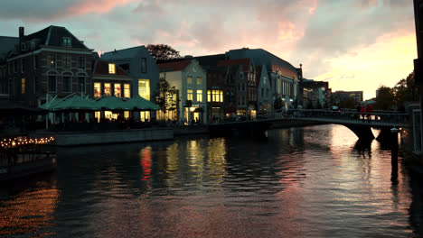 Colorful-time-lapse-footage-of-river-canals,walking-people-over-bridge-and-colorful-sunset-in-background-in-Leiden