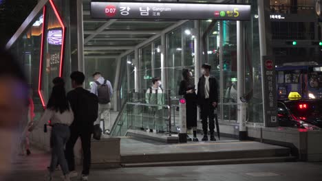 Gente-Coreana-Que-Viaja-En-La-Estación-De-Gangnam-Del-Centro-Con-Máscaras-Faciales-Por-La-Noche,-Pandemia-De-Covid-19,-Estático,-Seúl,-Corea-Del-Sur