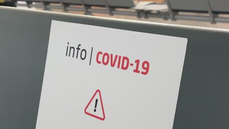 Coronavirus-Infoschild-Auf-Einem-Sitzplatz-Eines-Flughafens