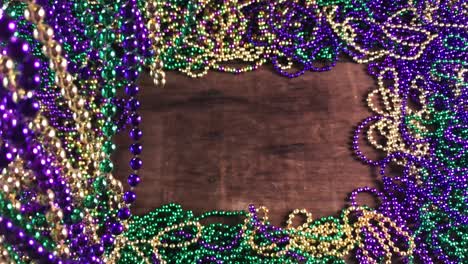 flat-lay-border-of-colorful-Mardi-Gras-beads-with-more-beads-hanging-on-side-moving-slightly