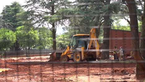 Construction-work-in-zoo-enclosure-through-fence,-slow-panning-shot-left-to-right