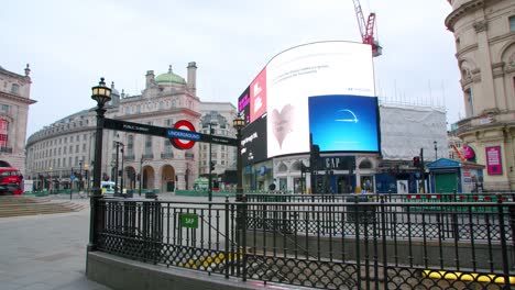 Lockdown-in-London,-Piccadilly-Circus-underground-completely-empty-during-the-corona-virus-pandemic-2020,-with-police-car-and-red-bus