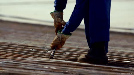 A-rebar-grid-is-tied-together-with-wire-before-pouring-the-cement-foundation