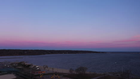 Eine-Luftaufnahme-über-Einen-Leeren-Park-Mit-Blick-Auf-Die-Bucht-Während-Eines-Wunderschönen-Sonnenaufgangs