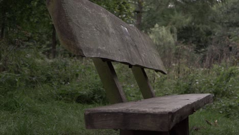 Rustic-wooden-bench-in-countryside-close-up-tilting-shot
