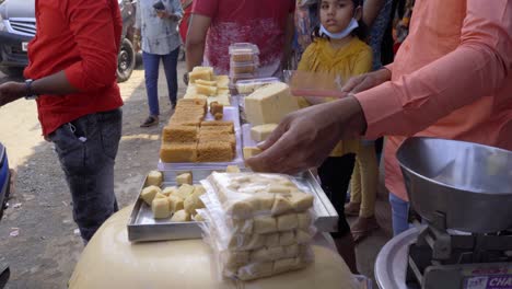 street-food-sweet-shopkeeper-cutting-in-cubes-Lonavala-Karla-mountain-India