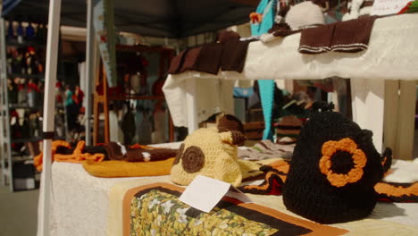 Handmade-knit-hats-and-accessories-for-sale-at-street-fair,-Slow-Motion