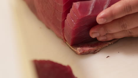Skilled-Chef-Slicing-A-Fresh-Tuna-On-A-Chopping-Board-In-The-Kitchen-Of-A-Japanese-Restaurant