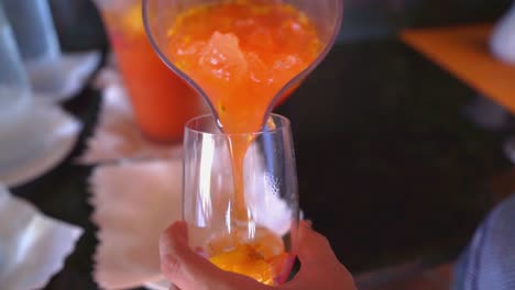 Pouring-passion-fruit-or-maracuja-juice-into-glass