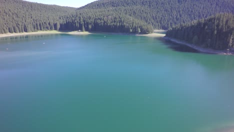 Drone-footage-over-clean,-green,-lake-water