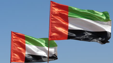 Emiratos-árabes-Unidos-Uae-Banderas-Nacionales,-Fondo-De-Cielo-Azul-Slomo